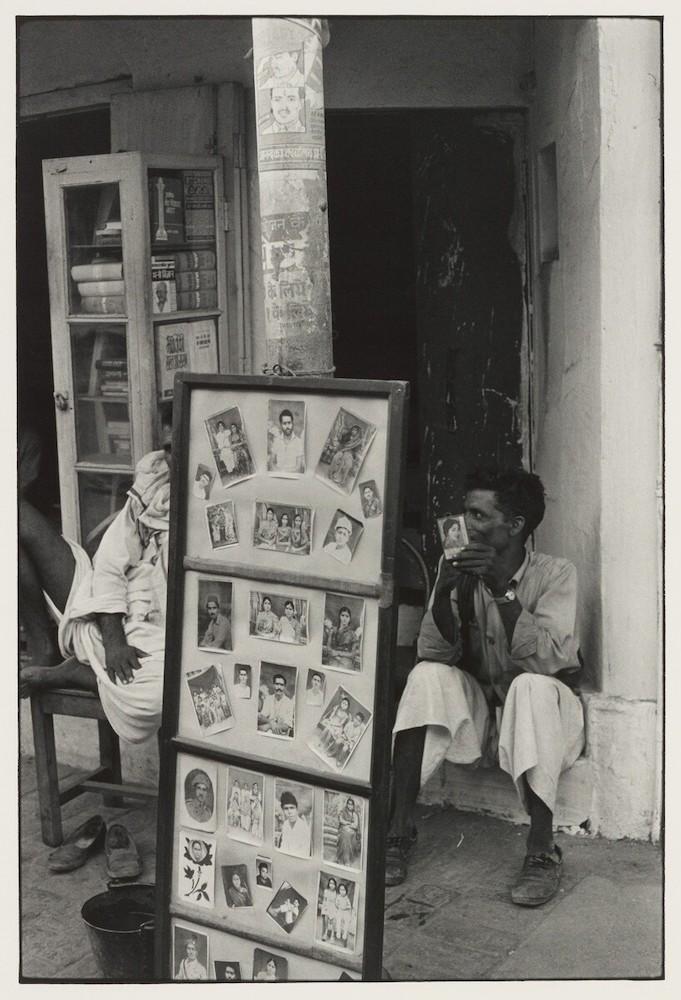 Outside a photography studio. One of the men in the photograph holds a picture in his hand, while the other is half obscured behind the multiple images on the display board. The proliferate practice of studio photography in India, with its whimsical customs and conventions, appears to have fascinated Gedney. (Varanasi, 1969–71. Image courtesy of William Gedney Photographs and Papers, David M. Rubenstein Rare Book & Manuscript Library, Duke University.)
