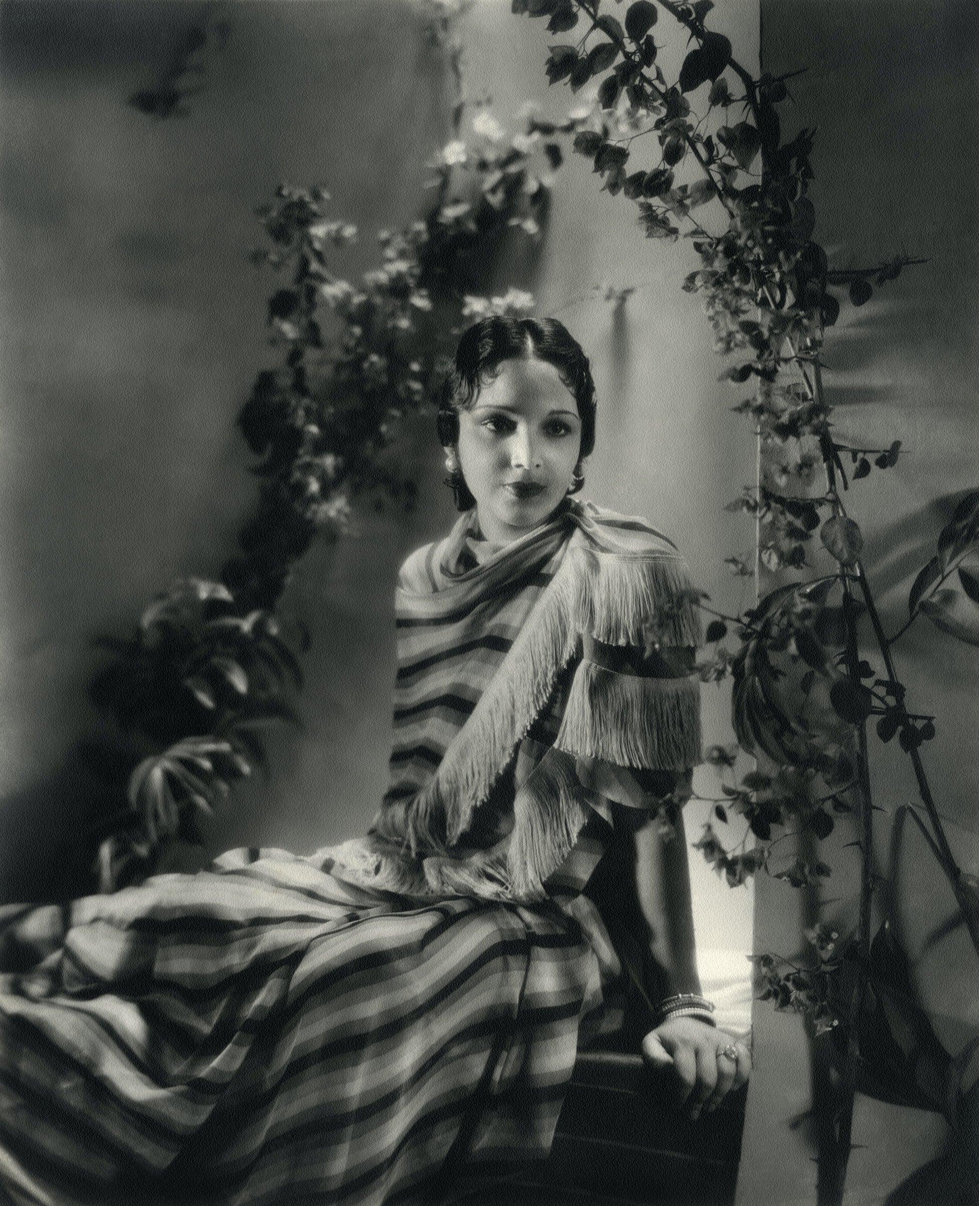 Devika Rani on the set of Jeevan Naiya. (1936, Bombay Talkies, d. Franz Osten). She was the indomitable star of Bombay Talkies and partner to Himansu Rai. The couple, who met in 1928, went on to study filmmaking techniques in Germany and opened the Bombay Talkies studio in 1934. She was one of the successful female leading stars of the studio, with many fans writing letters dedicated to her in film magazines and sending fan mail to the studio. Images such as these, with Devika Rani posing against the backdrop of their film, give us a glimpse into the concurrent practices of portraiture and photography that were prevalent at the time, while also highlighting Devika Rani’s star text.